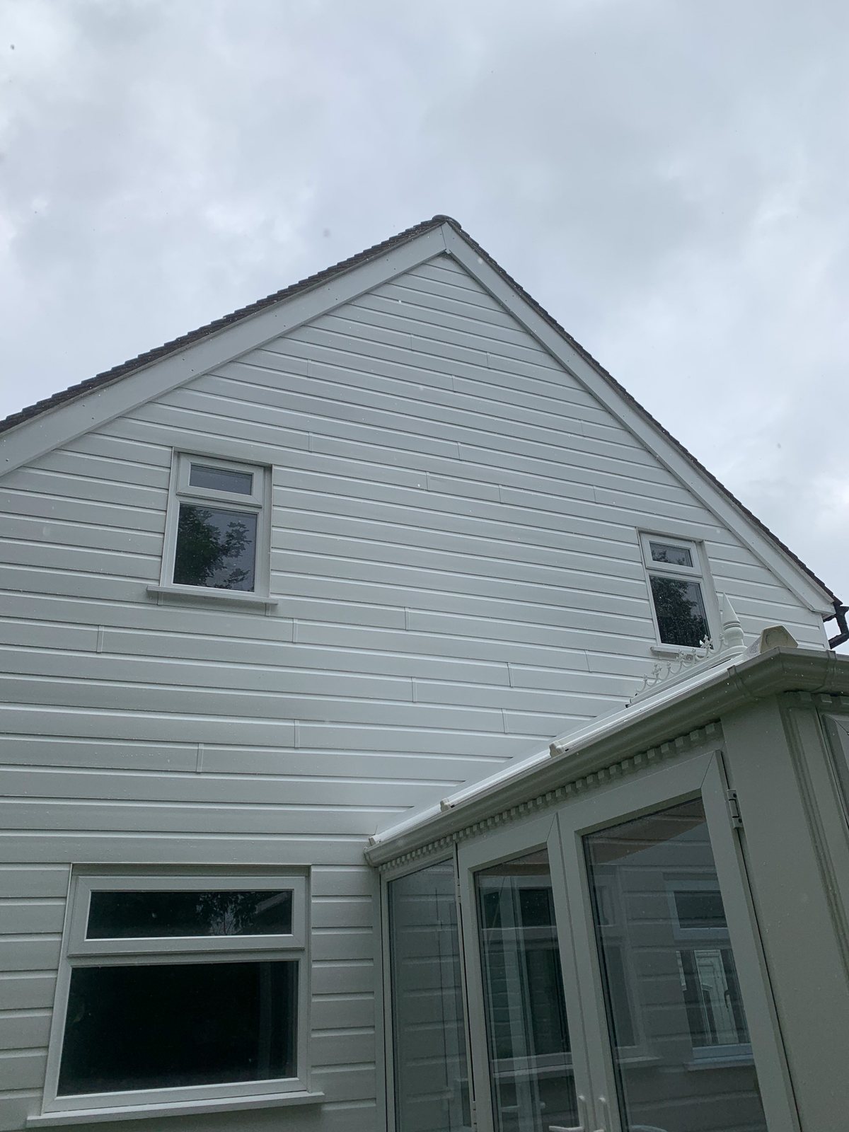 Conservatory and cladding cleaned in Dorking Surrey — white uPVC and grey cladding restored