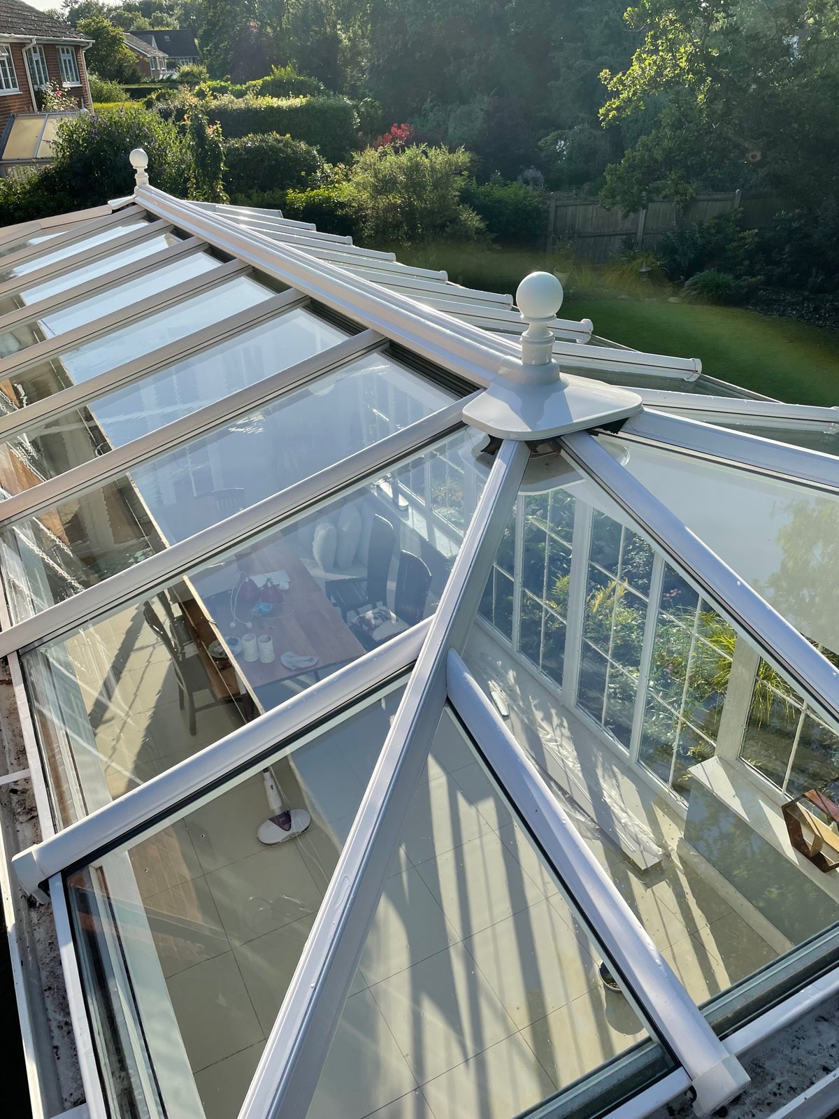 After: crystal-clear glass with the sky visible through the roof again.
