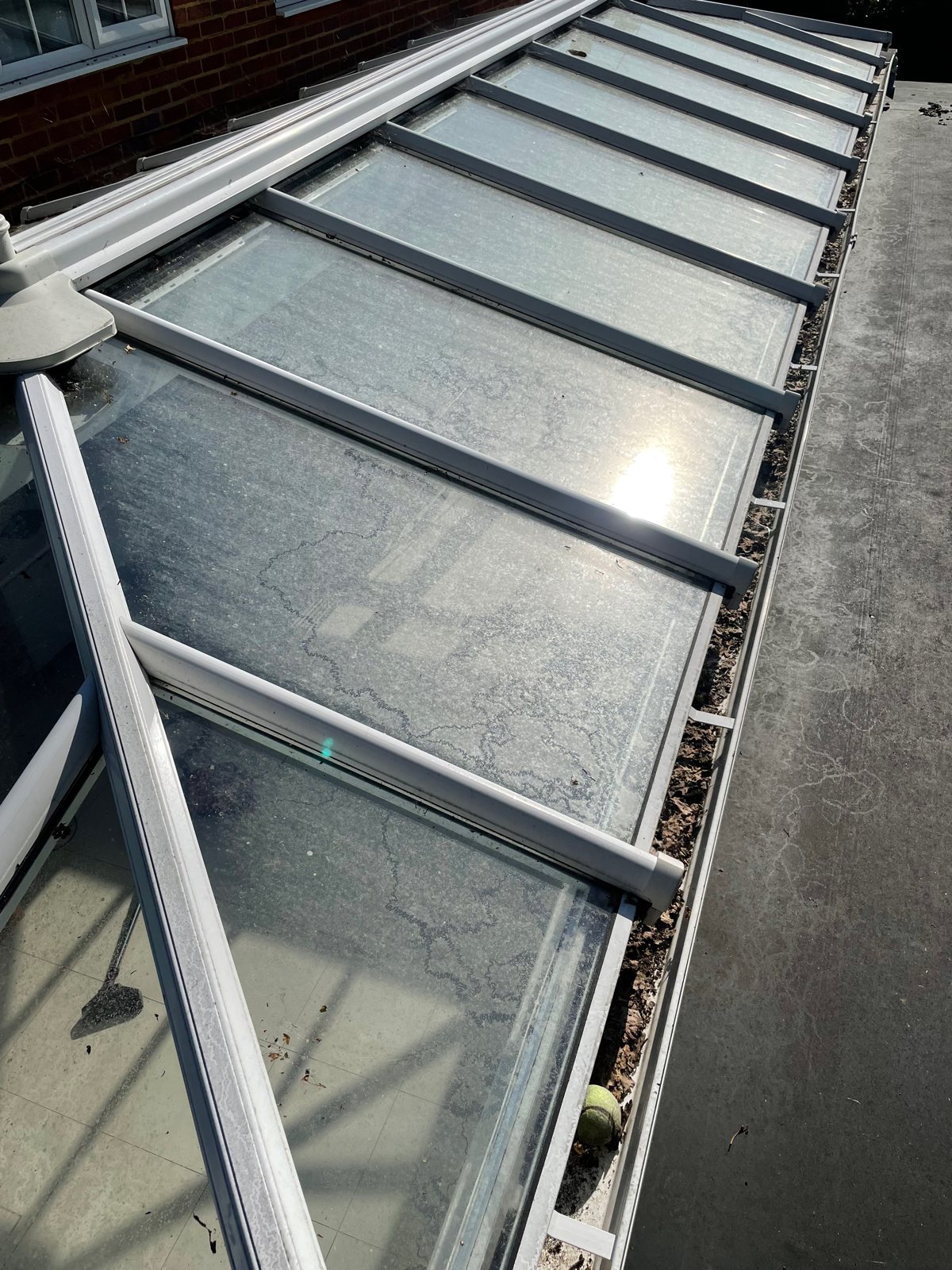 Before: a glazing panel clouded with algae and grime.