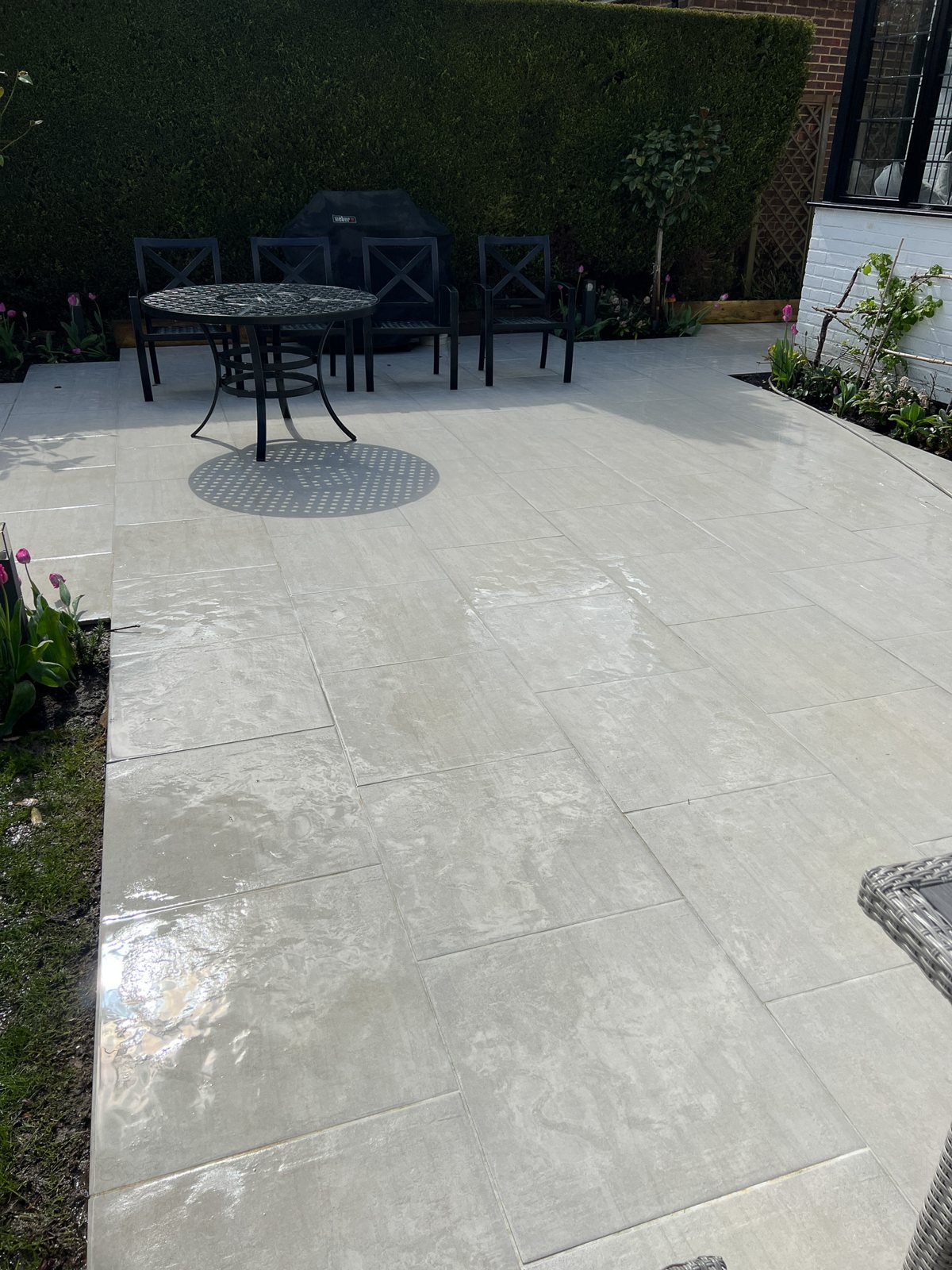 Porcelain patio cleaned in Ripley Surrey — light grey tiles restored and bright