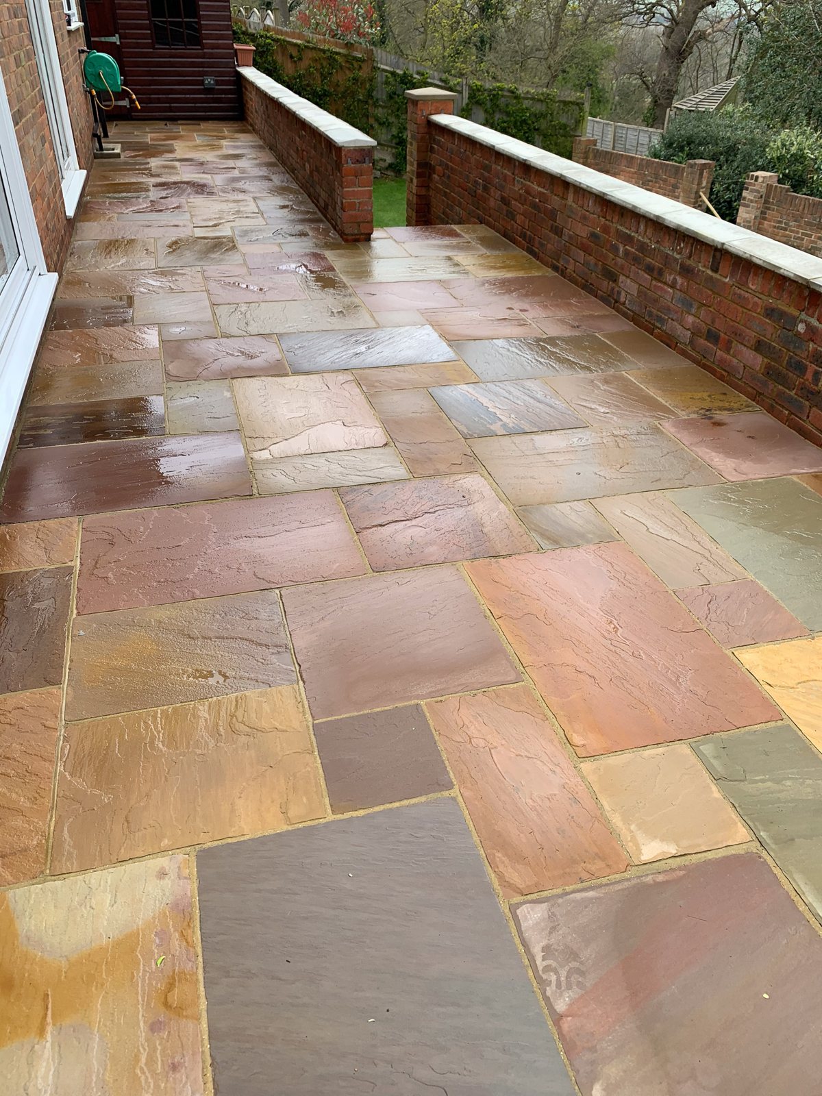 Sandstone patio in Godalming after cleaning — restored natural colour