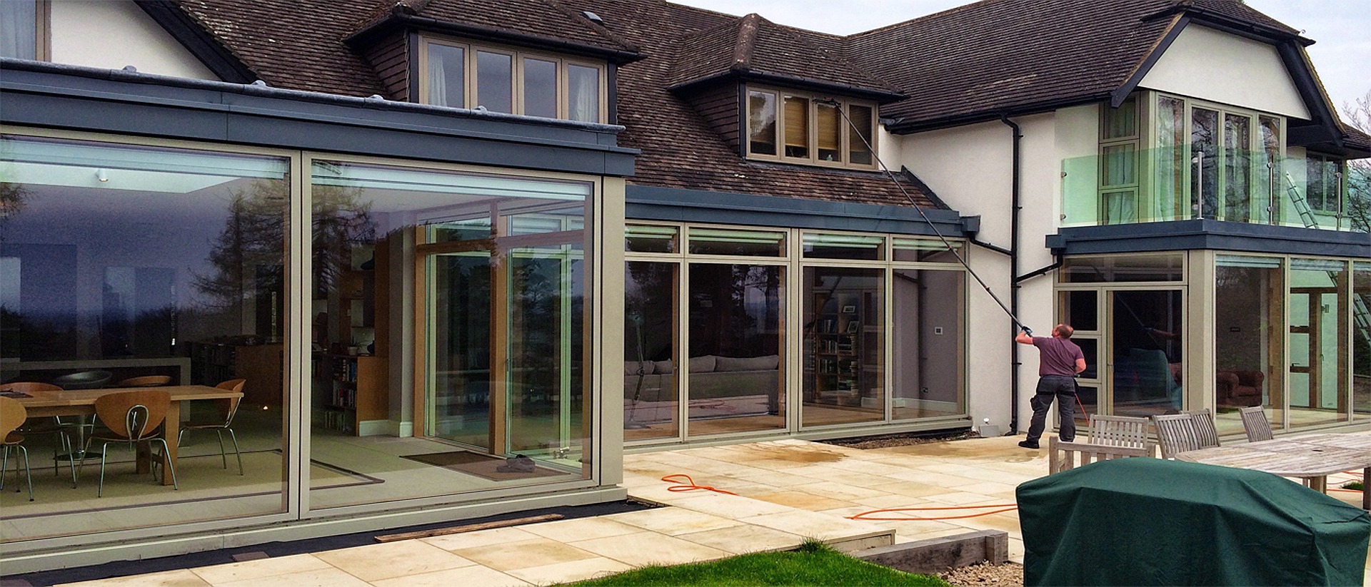 Window cleaning with a water-fed pole at a house in Dorking, Surrey