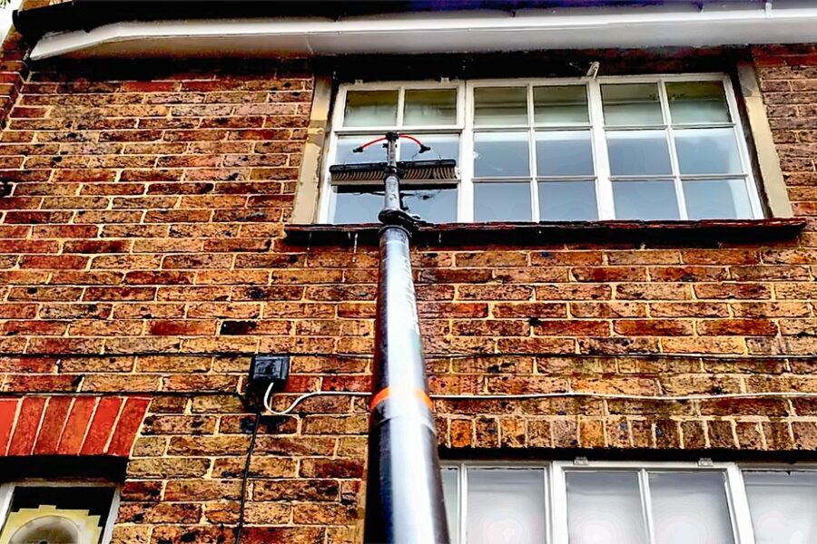 Water-fed pole cleaning an upstairs sash window in Surrey